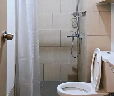a bathroom with a toilet and a shower at The Eve Place Staycation PH in Biñan