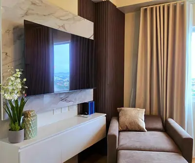 a living room with a couch and a tv at The Eve Place Staycation PH in Biñan