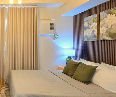 a bedroom with a bed and a painting on the wall at The Eve Place Staycation PH in Biñan