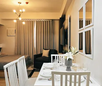 a living room with a table and a living room with a couch at The Eve Place Staycation PH in Biñan