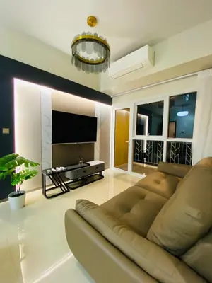 a living room with a couch and a flat screen tv at Savvy Suites Combined 6BR near Okada in Manila
