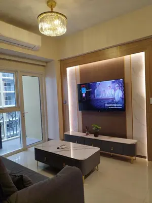 a living room with a couch and a tv on a wall at Savvy Suites Combined 6BR near Okada in Manila