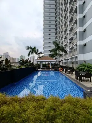a swimming pool in front of a building at Coast Residences in Manila