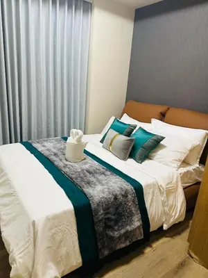 a bedroom with a large bed with white sheets and pillows at Savvy Suites Combined 5BR near Okada in Manila