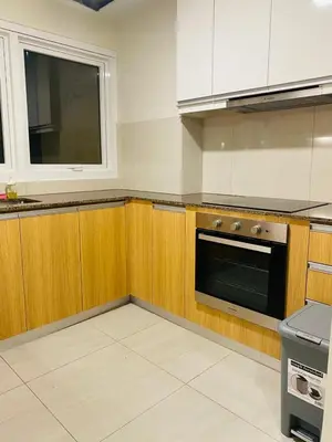 a kitchen with wooden cabinets and a black oven at Savvy Suites Combined 5BR near Okada in Manila