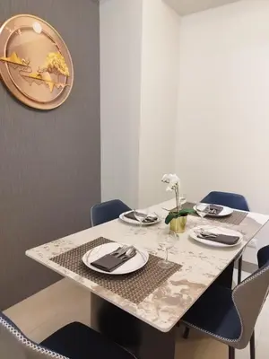 a dining room table with chairs and a large plate on the wall at Savvy Suites Combined 5BR near Okada in Manila