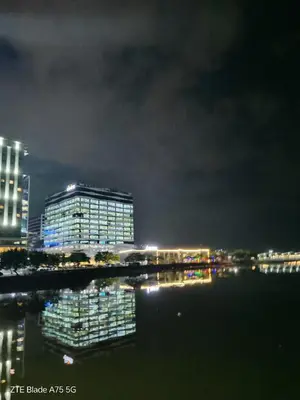 a night view of a building with lights in the water at HY Place Manila in Manila