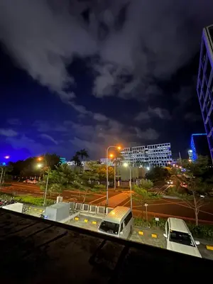 a city at night with cars parked in a parking lot at HY Place Manila in Manila