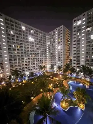 a large building with palm trees in a park at night at HY Place Manila in Manila