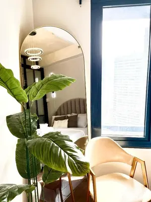 a mirror in a room with a plant and a bed at Air Residences - Elevate Escapes Makati, central location in Manila