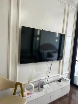 a living room with a large television on a wall at Air Residences - Elevate Escapes Makati, central location in Manila