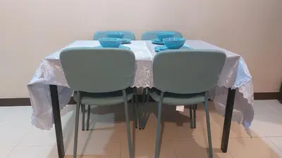 a table with four chairs and blue bowls on it at Affordable Whole 2 bedroom Condo high floor BGC in Manila