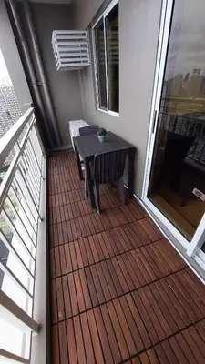 a balcony with a wooden table and a bench at Affordable Whole 2 bedroom Condo high floor BGC in Manila