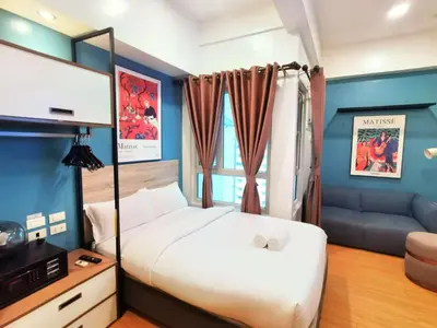 a bedroom with a large white bed and a couch at I suites in Manila