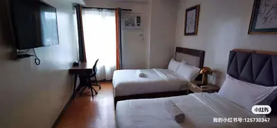 a hotel room with two beds and a television at I suites in Manila