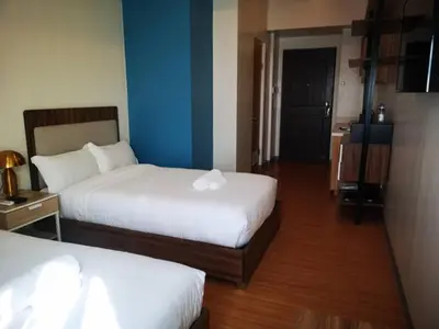 a hotel room with two beds and a blue wall at I suites in Manila