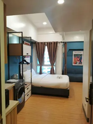 a bedroom with a large bed and a television at I suites in Manila