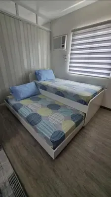 a bedroom with two beds and a window at Joms Cozy Staycation in Calamba