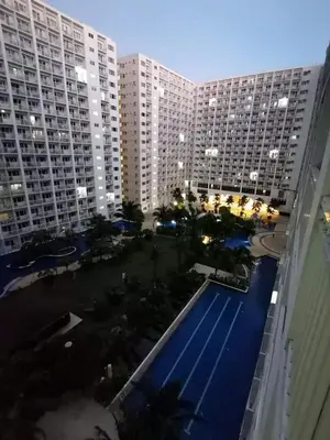 an aerial view of a large building with a swimming pool at Shore Condotel Metro Staycation in Manila