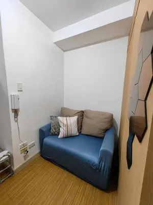 a blue couch in the corner of a room at VM Staycation Tower 3 Grace Residence Taguig in Manila