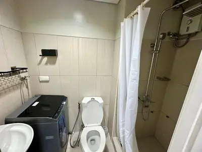 a bathroom with a toilet and a sink and a shower at Kathys Crib 11th flr at Shell Residence in Manila