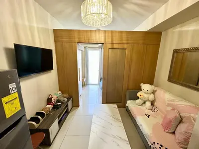 a small room with a teddy bear sitting on a couch at Kathys Crib 11th flr at Shell Residence in Manila