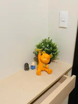 a toy cat sitting on a counter next to a plant at Savvy Suites 3BR Near Okada in Manila