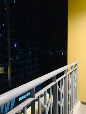 a balcony with a view of a city at night at Savvy Suites 3BR Near Okada in Manila
