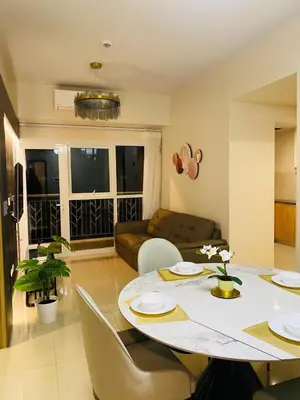 a living room with a table and a couch at Savvy Suites 3BR Near Okada in Manila