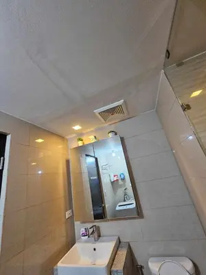 a bathroom with a sink and a toilet and a mirror at Serendipity staycation in Manila