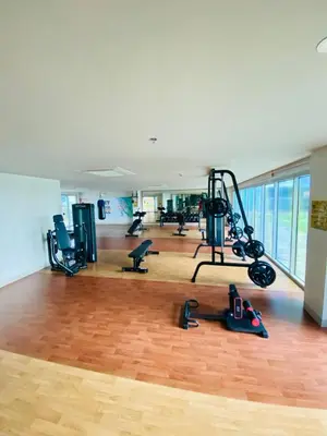 a gym with treadmills and exercise equipment on a wooden floor at Serendipity staycation in Manila