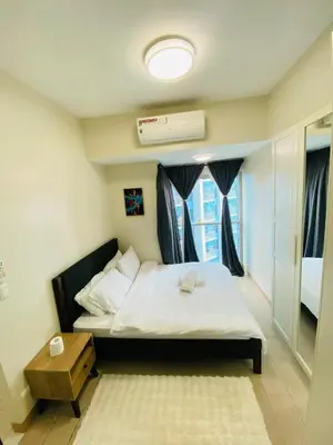 a small bedroom with a bed and a window at Serendipity staycation in Manila