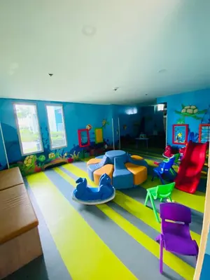 a childrens play room with a slide and chairs at Serendipity staycation in Manila