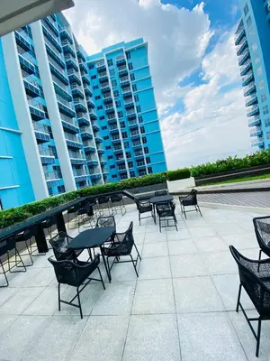 a patio with tables and chairs and buildings at Serendipity staycation in Manila