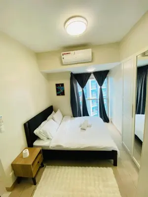 a small bedroom with a bed and a window at Serendipity staycation in Manila