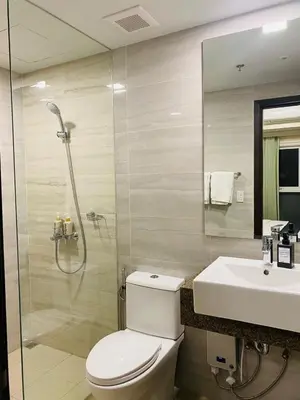 a bathroom with a shower and a toilet and a sink at Savvy Suites 2BR Okada View in Manila