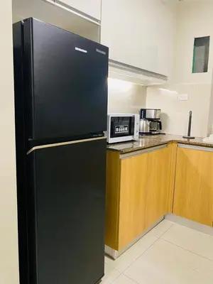 a black refrigerator in a kitchen with a microwave at Savvy Suites 2BR Okada View in Manila