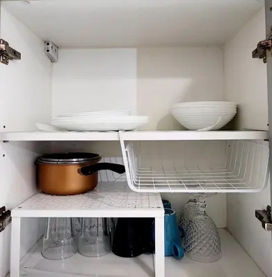 a white kitchen shelf with bowls and dishes on it at 14F BGC Unit 3 mins Walk to The Venice Grand Canal Mall Pet Friendly in Manila
