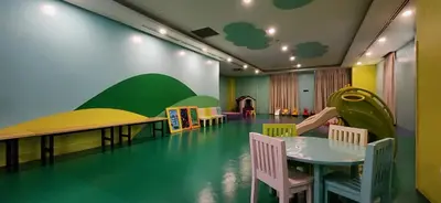 a room with a table and chairs and a play area at 14F BGC Unit 3 mins Walk to The Venice Grand Canal Mall Pet Friendly in Manila
