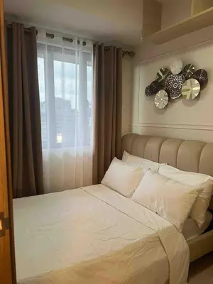 a bed in a room with a window and a bedvisor at Stylist hideaway in d heart of MOA in Manila