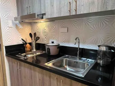 a kitchen with a sink and a counter top at Stylist hideaway in d heart of MOA in Manila