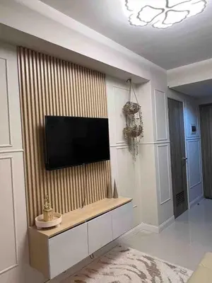 a living room with a flat screen tv on a wall at Stylist hideaway in d heart of MOA in Manila