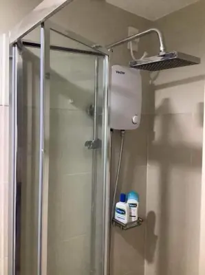 a shower in a bathroom with a glass shower stall at S Residence 3,Mall of Asia Area in Manila