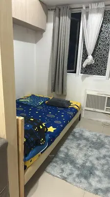 a bedroom with a bed with a blue comforter and a window at Chays Place in Manila