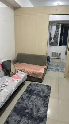 a room with a bed and a couch and a rug at Chays Place in Manila