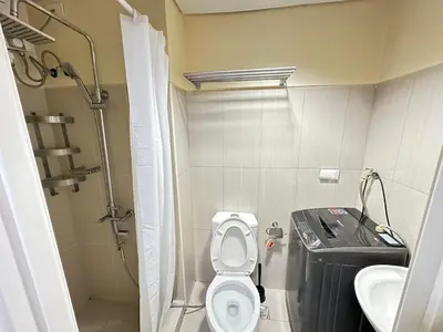 a small bathroom with a toilet and a sink at Kathys Crib Family Suite Room at Shell Residence in Manila