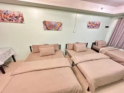 a room with four beds and a butterfly on the wall at Kathys Crib Family Suite Room at Shell Residence in Manila