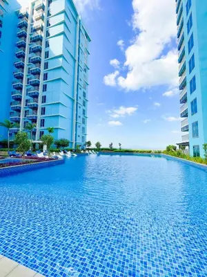 a swimming pool in the middle of two tall buildings at Luxury Apartment near Okada Manila and Solaire in Manila