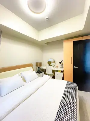 a bedroom with a white bed with a black door at Luxury Apartment near Okada Manila and Solaire in Manila