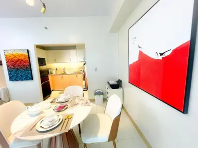 a dining room with a white table and white chairs at Luxury Apartment near Okada Manila and Solaire in Manila